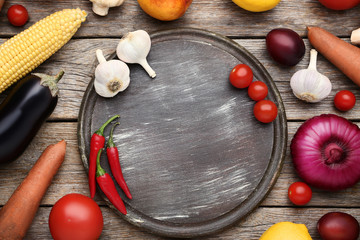 Fresh vegetables with cutting board on wooden table