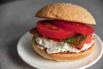 Sandwich with fresh salmon, tomato and cream cheese, closeup
