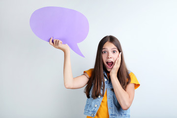 Young girl with speech bubble on grey background