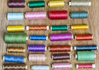 Multi Colored Thread Yarns on Wooden Background 