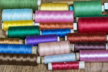 Multi Colored Thread Yarns on Wooden Background 