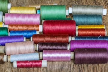 Multi Colored Thread Yarns on Wooden Background 
