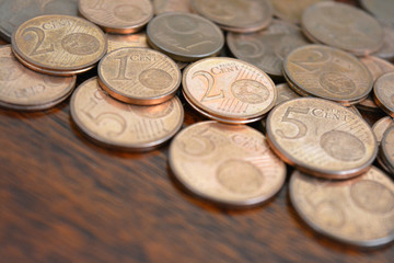 Euro cent coins. 1 euro, 2 euro and 5 euro cent coins on wood table.