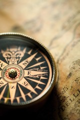 Fototapeta na wymiar Closeup of an Old Compass on an Old Map
