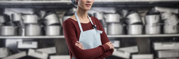 Composite image of female chef standing with arms crossed