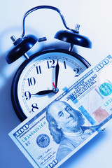 Time is money. Alarmclock with Dollars cash as symbol of business, wealth and work.