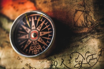 Obraz na płótnie Canvas Closeup of an Old Compass on an Old Map
