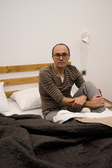 Fototapeta premium Man sitting on a bed in the bedroon