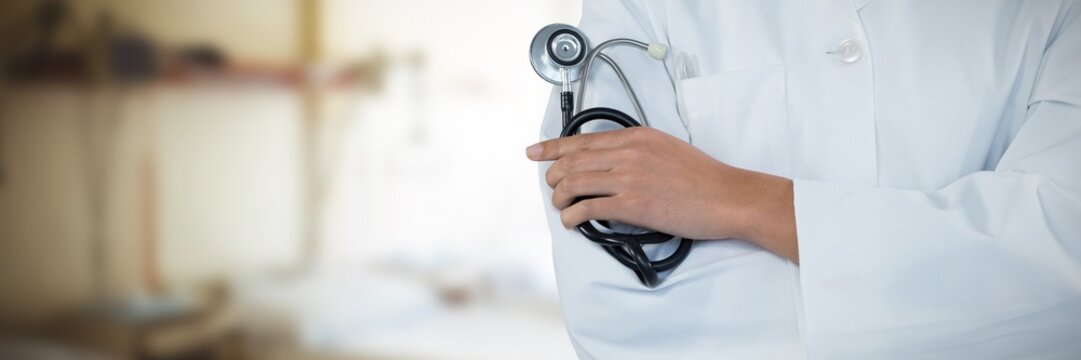 Composite image of doctor holding stethoscope against grey