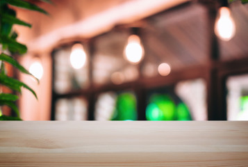Empty wooden table and blurred background of abstract in front of coffee shop or restaurant for display of product or for montage