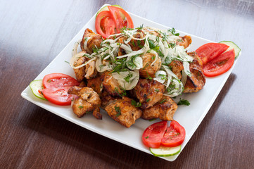 Fried skewers on the grill in a white dish