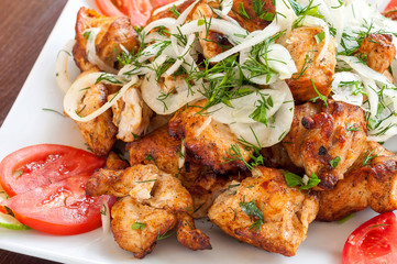 Fried skewers on the grill in a white dish