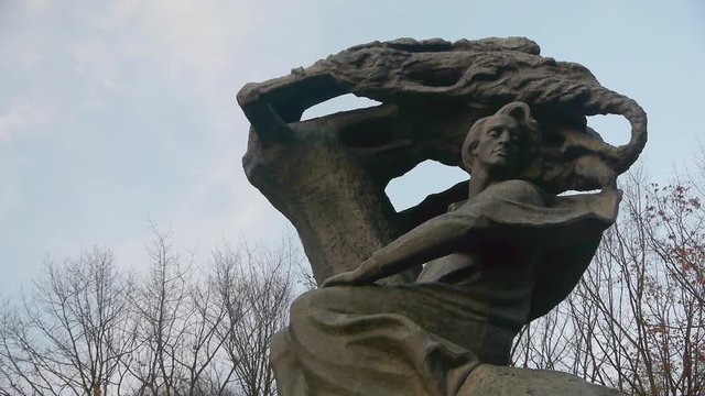 Close up of the Chopin Monument in Lazienki Park in Warsaw on an overcast day with the statue on the right of the frame