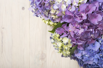 Hydrangea flowers on white wooden background. Top view. Floral border with copy space.
