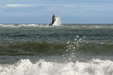 High Tide Causes Huge Waves to Break Along Shore and Around Distant Lighthouse