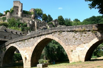 Fototapeta na wymiar Old stone bridge on the Aveyron river and medieval village of Belcastel 