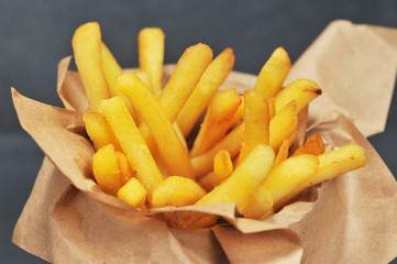 Fried potato on kraft paper.  The image of the potato occupies the entire frame space. Close-up. Macro photography.