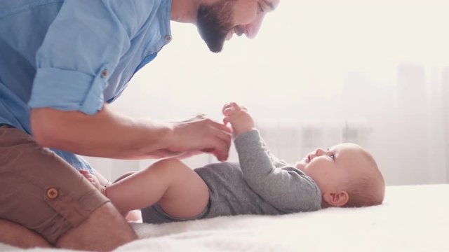 Affectionate father tickling cute little baby