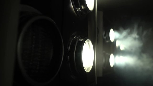 Large projectors with flickering light create color music . Close up