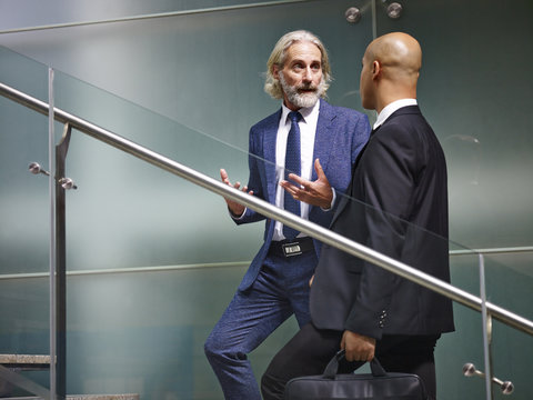 two corporate executives talking while ascending stairs