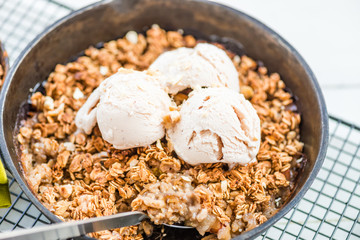 Homemade cooked rhubarb and apple crumble with oatmeal and vanilla ice cream