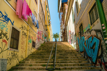 Escadaria em rua com prédios pichados