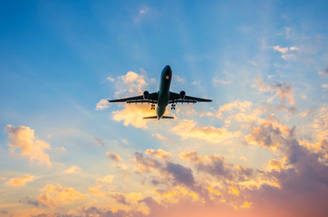 Dark silhouette of an airplane at sunset approach in the airport of a beautiful beautiful sky.