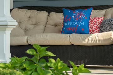 An outdoor couch with a patriotic pillow