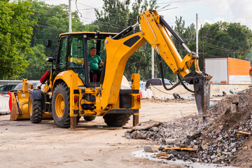 Fototapeta na wymiar large construction machinery, special car for repairing yellow color with pneumatic hammer