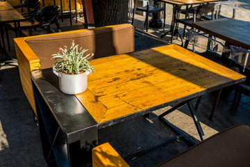 Wooden table with armchairs in a street cafe