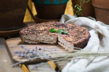 Soft homemade cheesecake (cottage cheese pie, casserole, zapekanka) vanilla chocolate with cinnamon on a cutting board on a terrace among flowerpots on a summer clear day