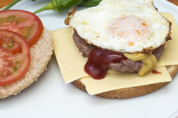 Hamburguesa con lonchas de queso, rodajas de tomate y un huevo a la plancha