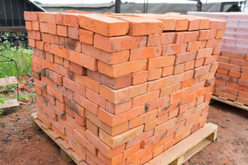 The bricks are stacked on wooden pallets and prepared for sale. Clay brick is an ecological building material.