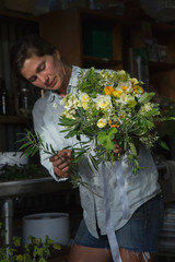 A flower farmer designs and displays a bouquet from flowers she has grown