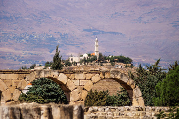Mosque on a hill seen from Umayyad ruins with Mountains in the background at Anjar, Bekaa valley, Lebanon