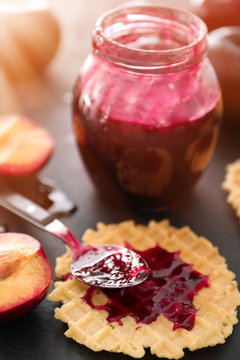 Wafer with tasty plum jam on table