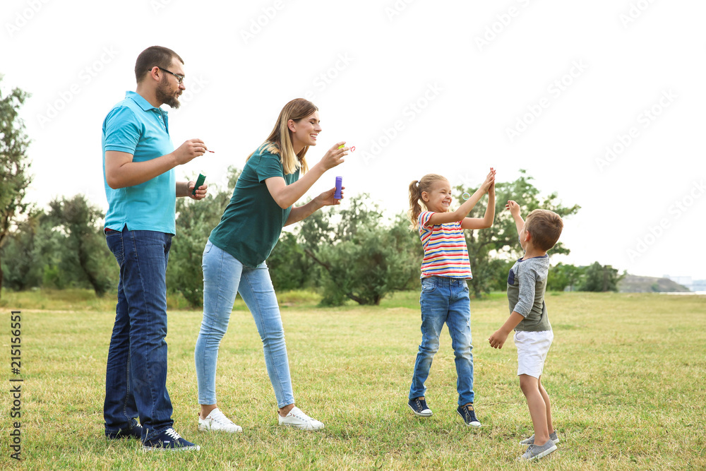 Wall mural happy family playing together with their children outdoors