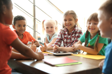 Little children sitting together at table indoors. Unity concept