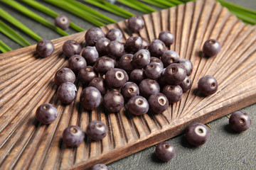 Fresh acai berries on wooden board, closeup