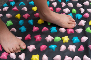 boy walking on a foot massage pad with plastic domes