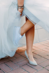 Young beautiful bride choosing between high heels and canvas shoes