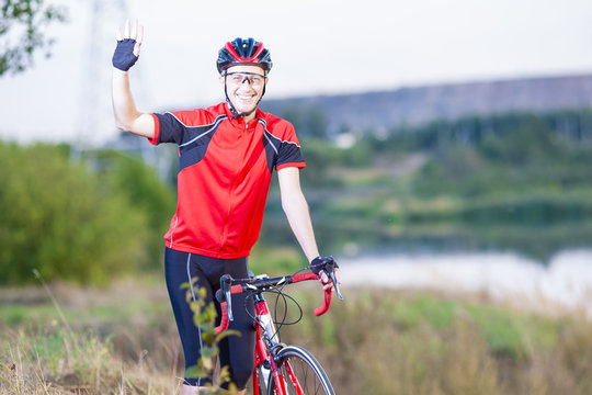 Portrait of Make sportsmen With Road Bike Outdoors Showing High Five and smiling.