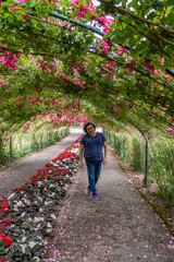 Fototapeta na wymiar tunnel of roses with a young woman