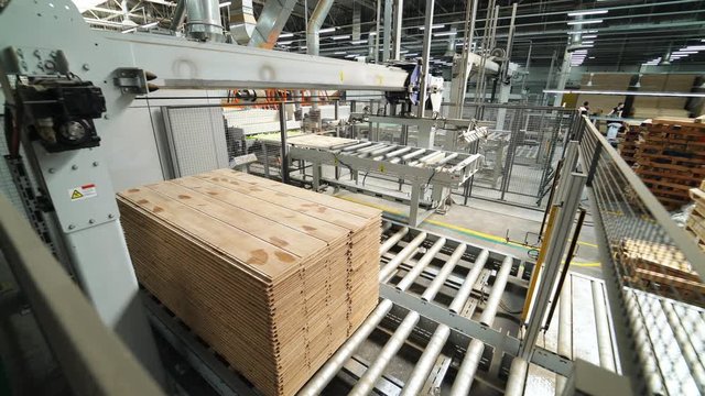 Floorboard production in the industrial factory. Manufacturing of a parquet board. Modern technologies.