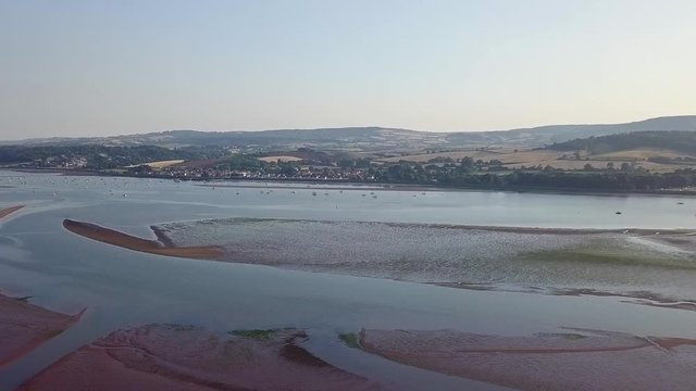 Wide view from the sky of the beach in southwest England, Lympstone. The drone glides downward giving the aerial a different perspective.