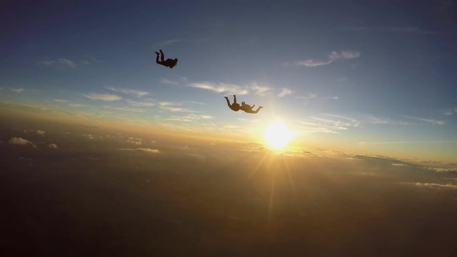 Skydivers having fun at the amazing sunset 4K video