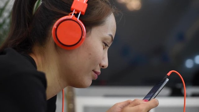 Young woman wears listening to music on the music player at home