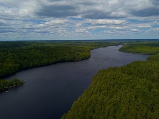 Aerial view over Raslången lake in south Sweden. Wild island covered with forest. Overcast with clouds.