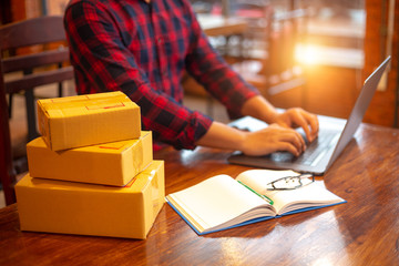Online shopping young start small business in a cardboard box at work. The seller prepares the...