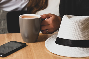 The female hand holds a cup of tea.